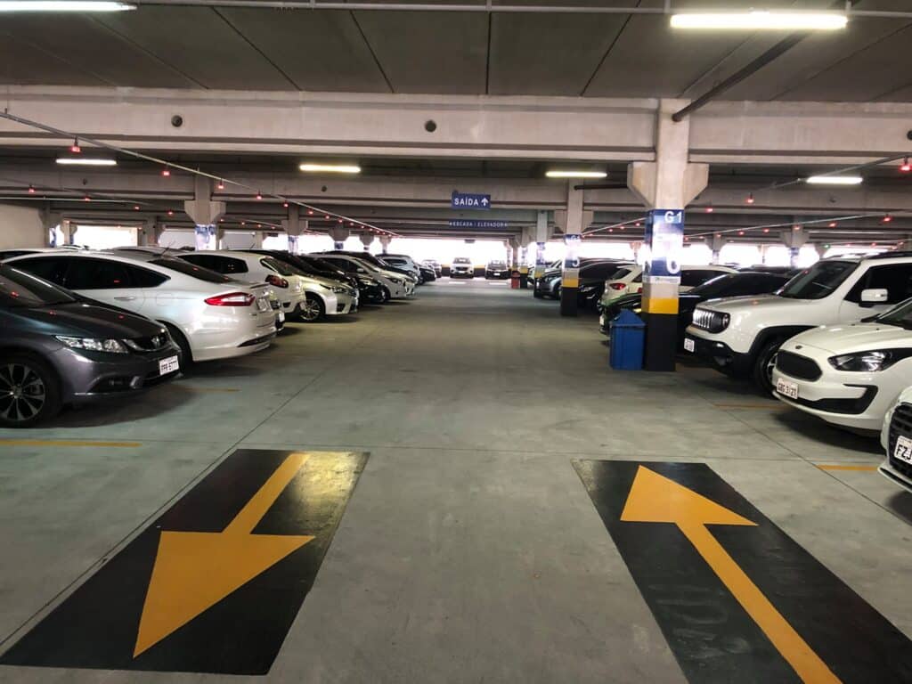 Diversos carros estacionamentos em um estacionamento coberto igual ao de shoppings