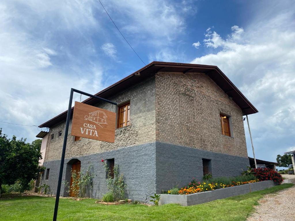 Casa Vita BG - casa de campo uma construção em pedra e com tijolos aparentes, cercada por um gramado, em Bento Gonçalves