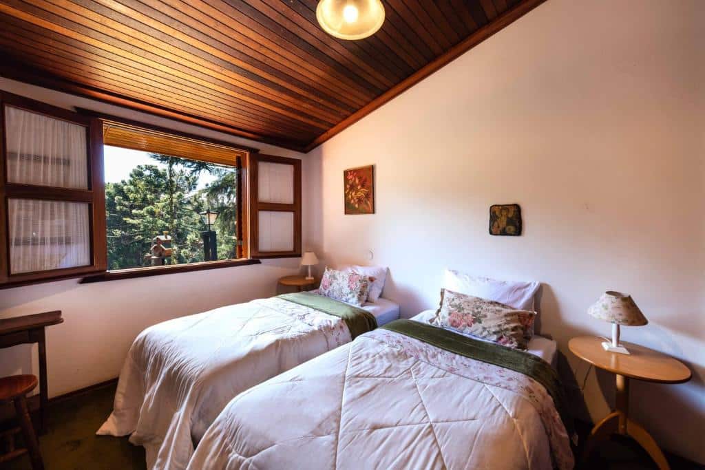 Quarto da Casa Xamego Alto Padrão com pôr do sol espetacular com duas camas de solteiro, uma janela, chão de madeira, duas mesinhas de cabeceira com abajures