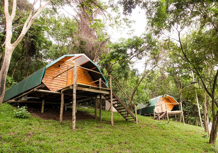 Frente do Viva Brotas – Chalés e Cabanas na Mata com arquitetura de madeira, gramas e árvores. Representa chalés em Brotas.