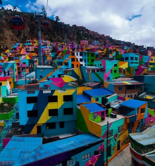 Casas bem coloridas com teleférico passando durante o dia, ilustrando post chip celular La Paz.
