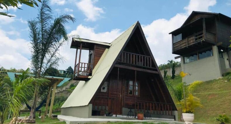 Vista de frente do Chalé da Montanha, em Águas de Lindóia, durante o dia com arquitetura de madeira.
