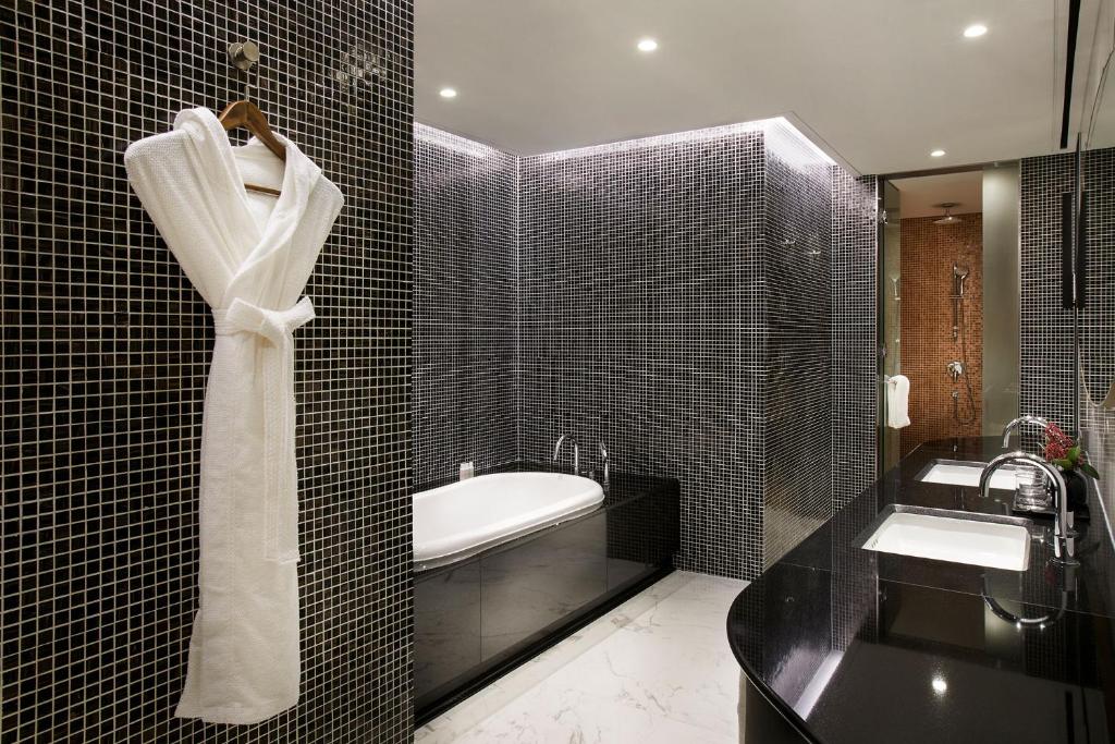 Banheiro do L7 Gangnam by LOTTE com uma banheira, um roupão, uma pia com duas cubas, para representes hotéis na Coreia do Sul