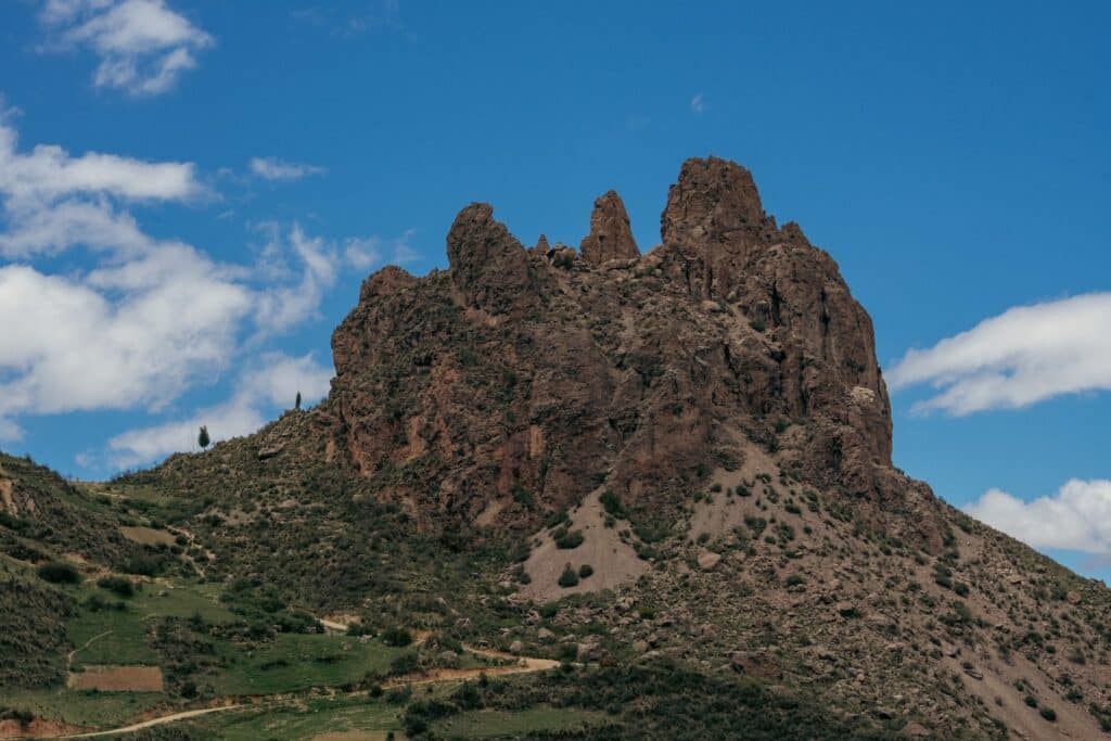 Grande pedra marrom no meio da montanha com áreas verdes em volta durante o dia, ilustrando post chip celular La Paz.