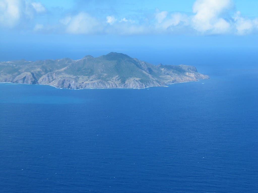 Ilha de Montserrat, uma porção de terra no meio do oceano azul, representa a ilha.