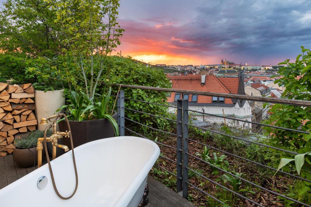 Varanda do MOSAIC HOUSE Design Hotel com uma banheira de hidromassagem com vista para a cidade, para representar hotéis em Praga