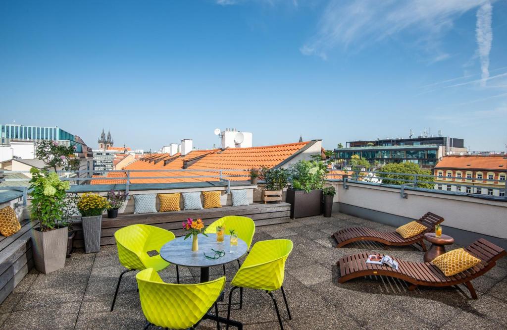Terraço compartilhado do NYX Hotel Prague by Leonardo Hotels com espreguiçadeiras, almofadas, mesas e cadeiras, o local oferece um pouco de vista da cidade