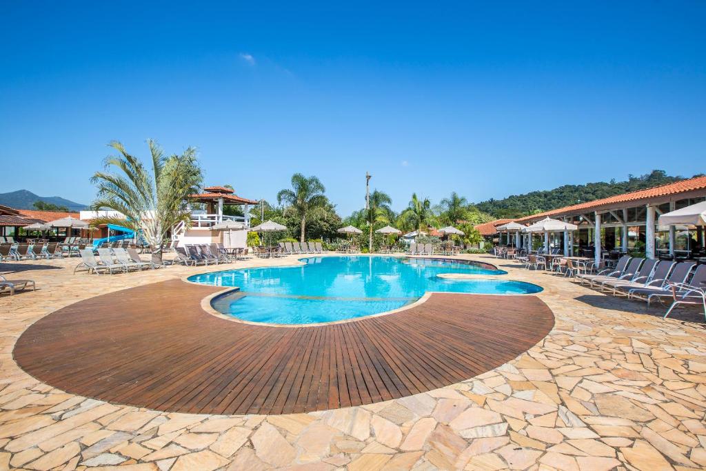 Piscina do Hotel Fazenda Hípica Atibaia durante o dia com cadeiras em volta da piscina. Representa resorts em Atibaia.