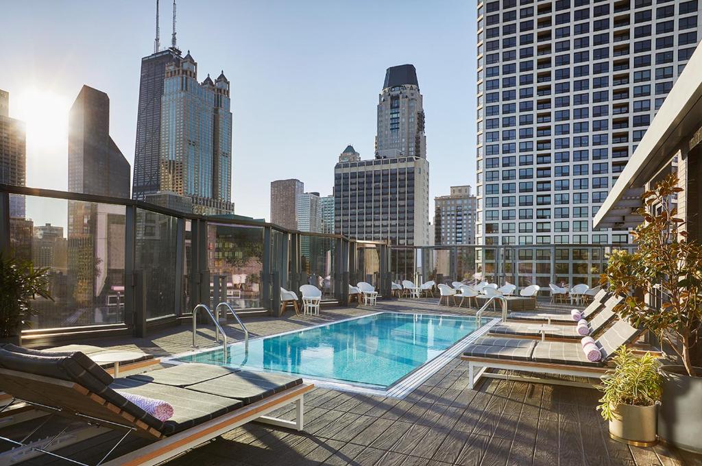 Vista da piscina na cobertura do Viceroy  durante o dia com cadeiras em volta da piscina. Representa hotéis em Chicago.