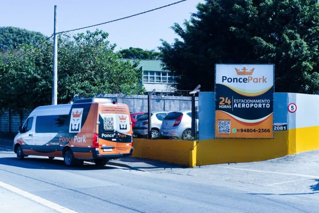 Esquina do Ponce Park com placa de divulgação, uma van da empresa saindo do local