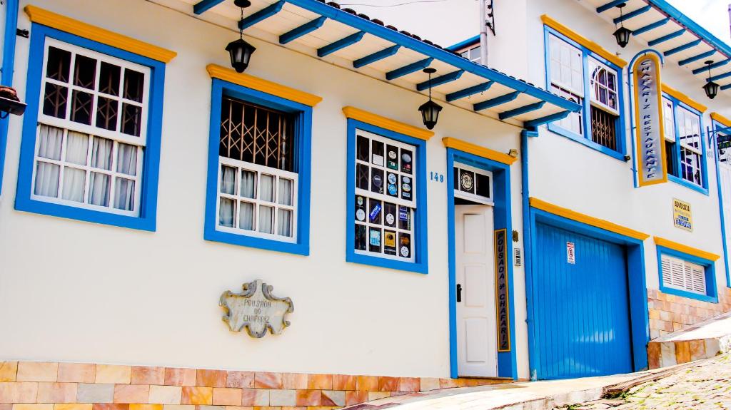 frente da Pousada do Chafariz em Mariana com arquitetura colonial e umbrais de janelas e portas pintados nas cores azul e amarelo