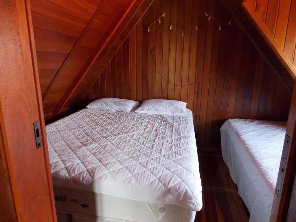Quarto do Chalé aconchegante em Brotas SP com cama de casal do lado esquerdo e cama de solteiro do lado direito.