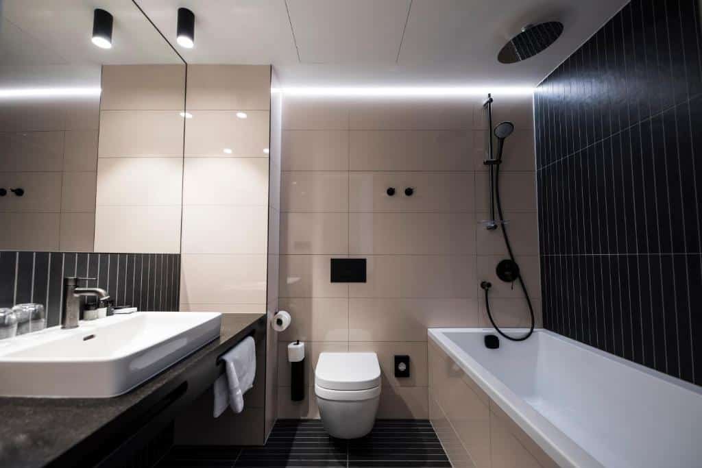 Banheiro do The Gold Bank  com uma banheira, um vaso sanitário, uma pia ampla e um espelho
