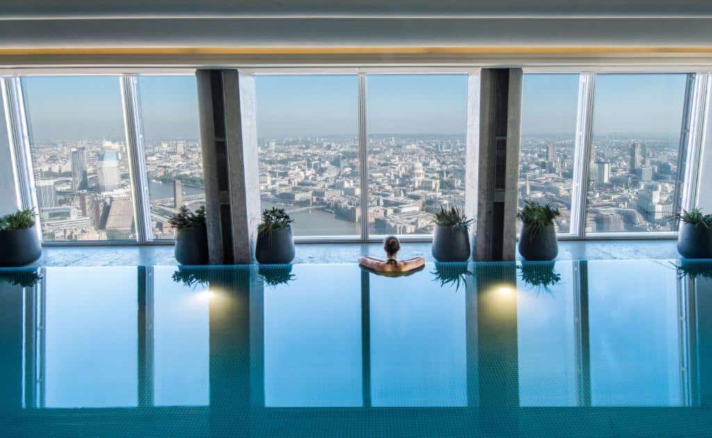 Piscina coberta do Shangri-La The Shard, London de frente para janelas panorâmicas com vista para a cidade e o rio Tâmisa