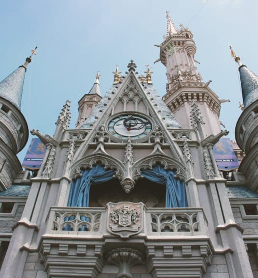 vista de perto e de baixo do castelo com inspiração gótica e barroca, bem detalhado em branco com detalhes em azul no The Magic Kingdom, na Disney, uma das opções de onde ficar em Orlando