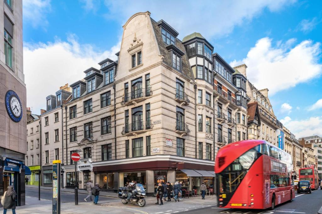 Prédio do The Resident Covent Garden em uma esquina movimentada com ônibus e pessoas passando em frente do local, para representar os hotéis bem localizados em Londres