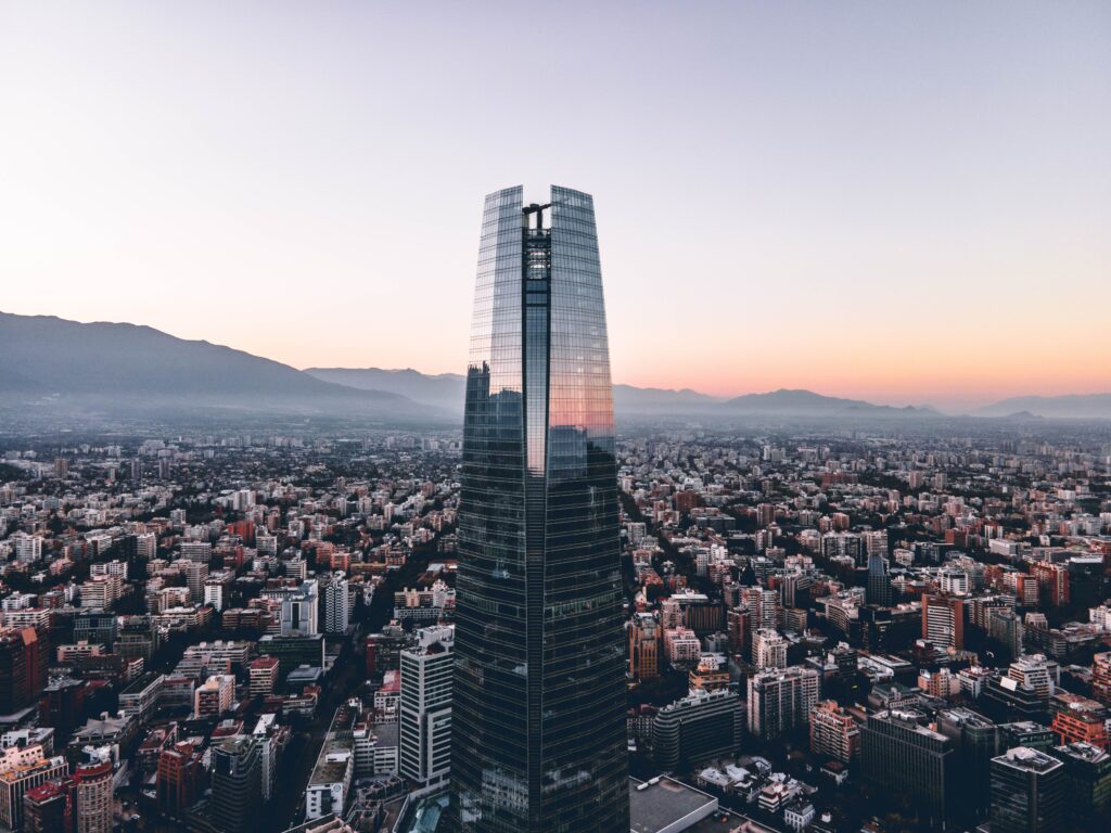 Vista da cidade de Santiago, durante o dia  com prédio no centro envolta de outros prédios. Representa Airbnb em Santiago.