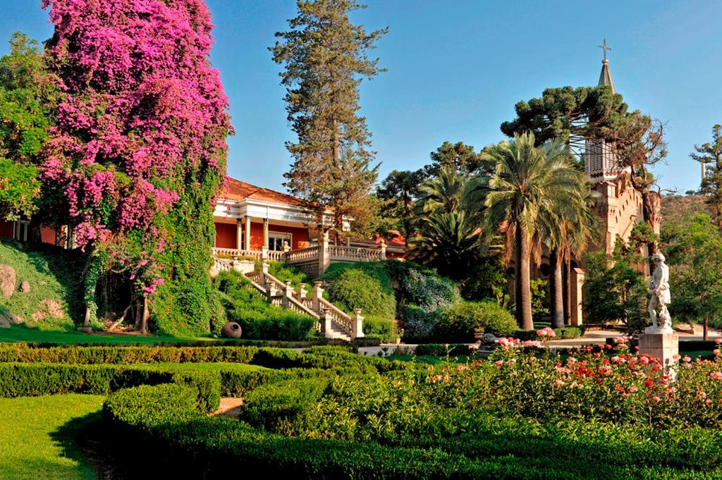 Frente do Hotel Casa Real – Viña Santa Rita durante o dia com um belo jardim a frente e ao fundo o hotel.