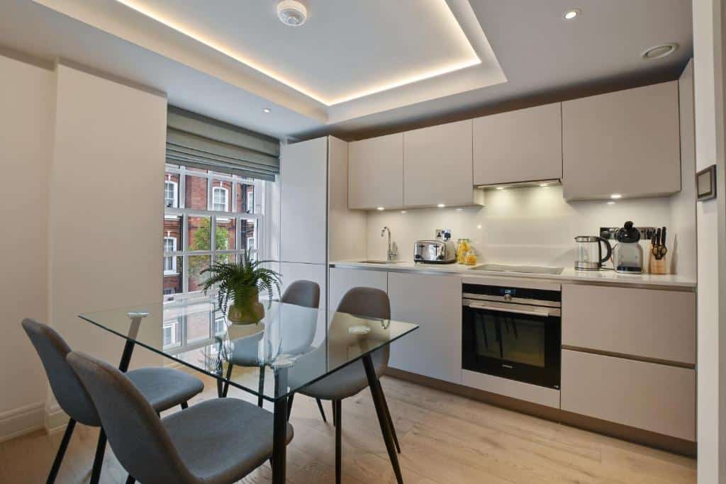 Cozinha do Hope House Residences by Q Apartments com uma janela ampla, uma mesa de vidro om quatro lugares, chão de madeira, para representar aluguel de temporada em Londres