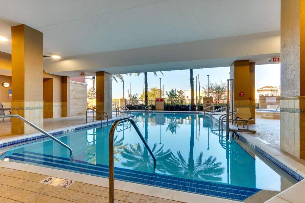 piscina interna do Drury Inn & Suites Orlando near Universal Orlando Resort, um dos hotéis na International Drive em Orlando, em formato retangular com escadinha e janelas de vidro