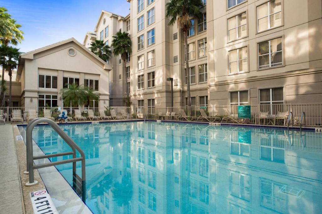 piscina retangular refletindo a fachada do Homewood Suites by Hilton Orlando-Intl Drive/Convention Ctr, um dos hotéis para brasileiros em Orlando