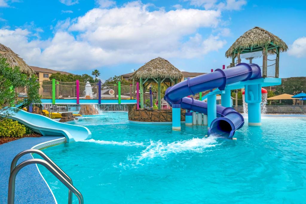 piscina com escadinha,  tobogã e passarela acima da água no Liki Tiki Village, um dos melhores hotéis em Orlando