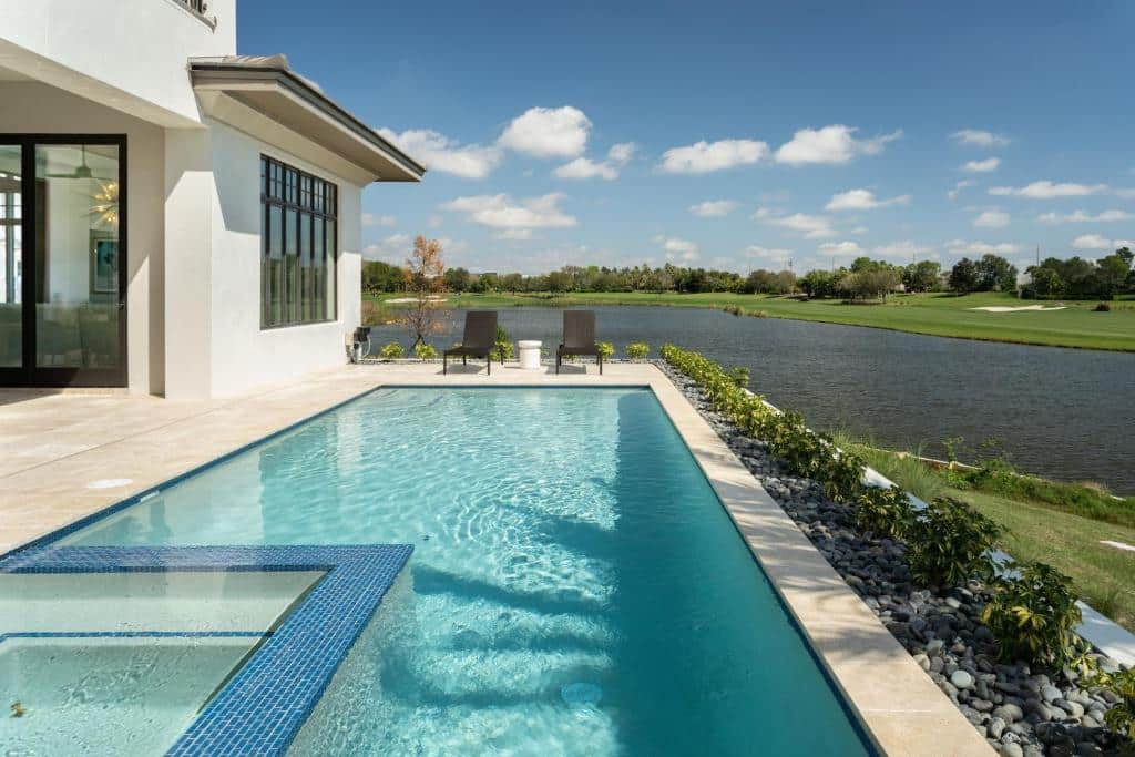 piscina com vista do lago com duas espreguiçadeiras no The Ritz-Carlton Orlando, Grande Lakes, um dos hotéis românticos em Orlando