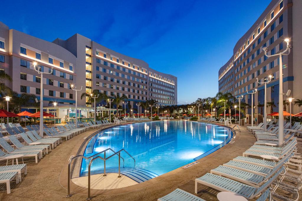 piscina com bordas mais ovaladas com a fachada atrás do Universal's Endless Summer Resort - Surfside Inn and Suites, um dos hotéis na International Drive em Orlando