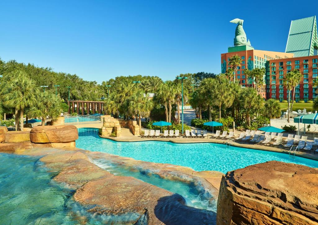 piscina do Walt Disney World Dolphin, um dos melhores hotéis em Orlando, com muitas árvores ao fundo e uma estrutura que parece uma cachoeira com pedras