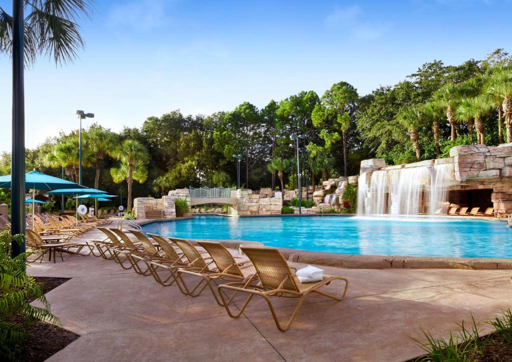 piscina do Walt Disney World Swan um dos hotéis românticos em Orlando com cascata e espreguiçadeiras ao redor