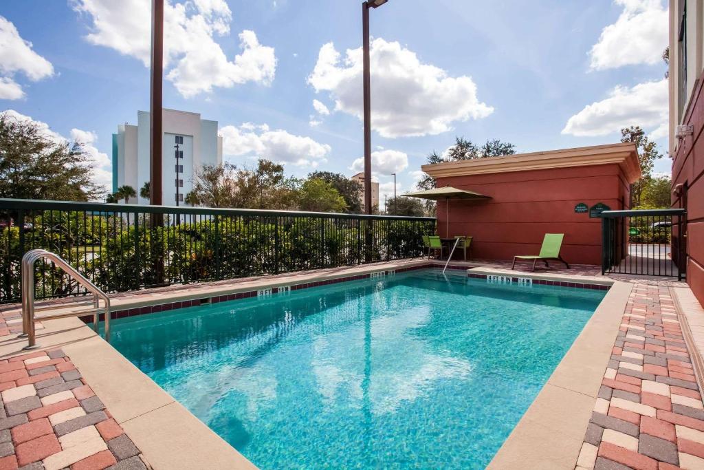 piscina retangular do Wingate By Wyndham - Orlando International Airport, um dos hotéis perto do aeroporto de Orlando, no terraço, com cadeiras ao redor e vista da região