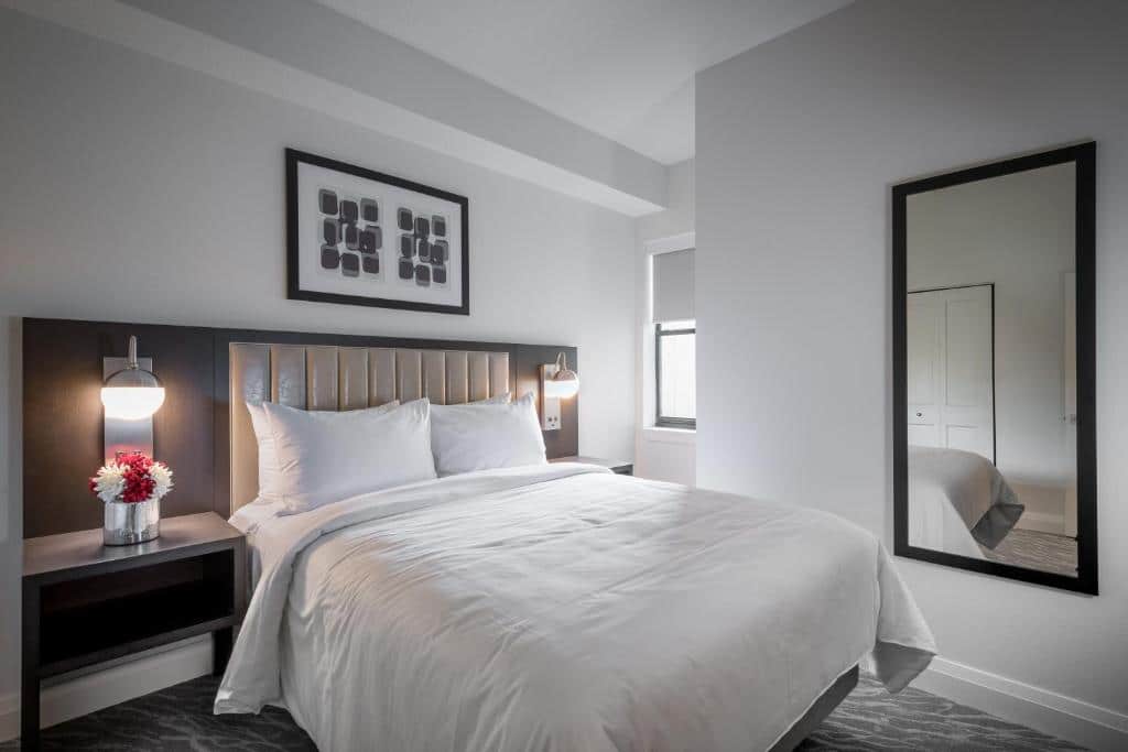 quarto do The Grove Resort & Water Park Orlando com cama de casal, espelho, luminárias em ambos os lados da cama