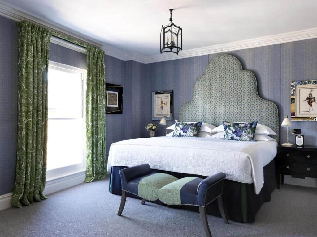 Quarto do Charlotte Street Hotel, Firmdale Hotels com uma cama de casal, uma janela com cortinas, um pequeno lustre, duas mesinhas de cabeceira e o chão é de carpete