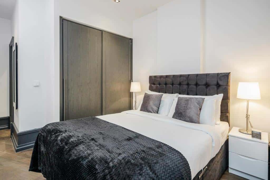 Quarto do Kula London - Covent Garden Garrick St com uma armário, uma cama de casal e duas mesinhas de cabeceira com abajures para representar airbnb em Londres