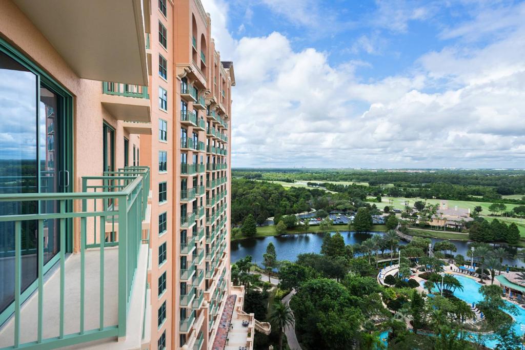 sacada de um quarto do JW Marriott Orlando Grande Lakes, um dos hotéis de luxo em Orlando, com vista da piscina e de ambientes arborizados