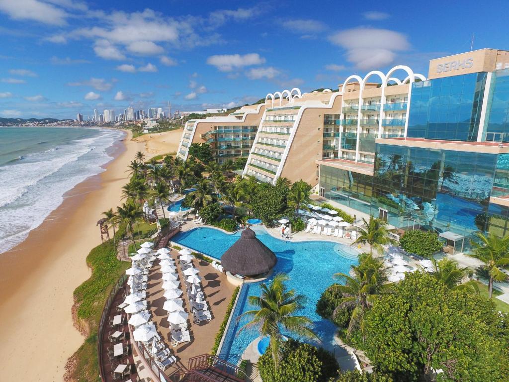 Vista da piscina, jardins verdes e espreguiçadeiras à beira-mar do Serhs Natal Grand Hotel & Resort