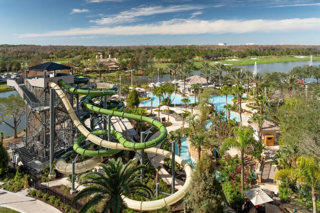 vista do tobogã no The Ritz-Carlton Orlando, Grande Lakes com piscinas. árvores e a fcahada do hotel ao fundo