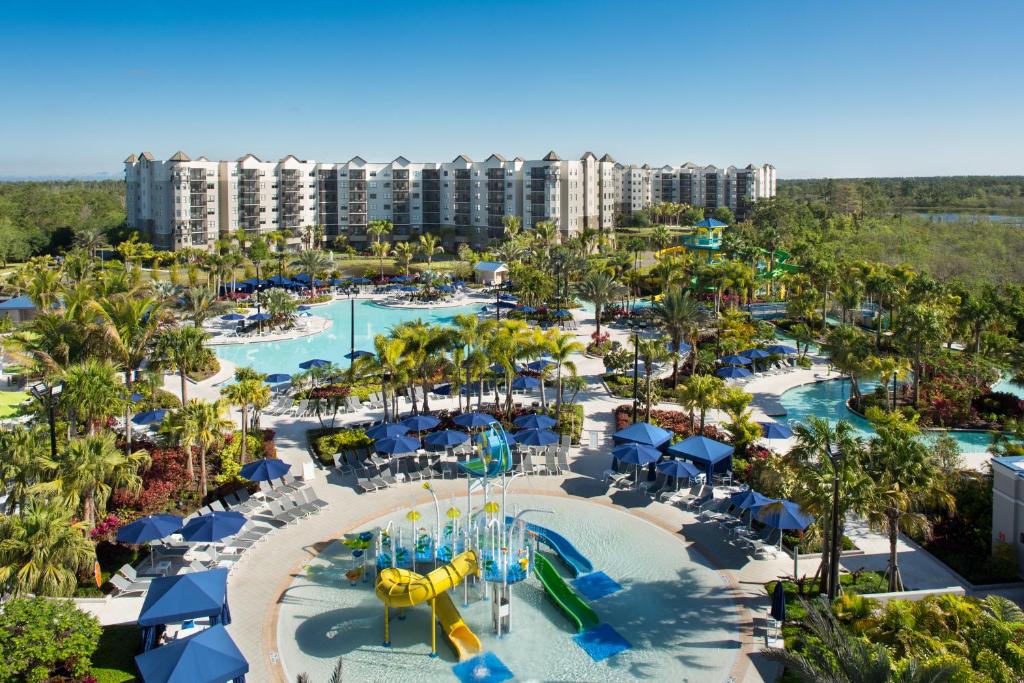 vista do The Grove Resort & Water Park Orlando, um dos resorts em Orlando, com piscinas, palmeiras e um parque aquático colorido