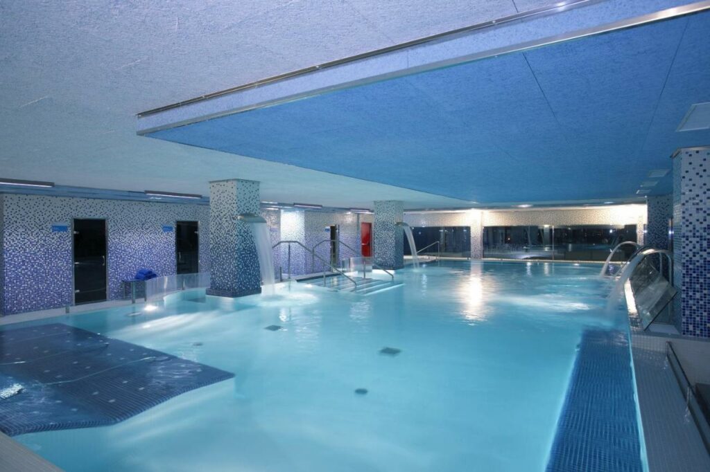 Spa do Alexandre Hotel Frontair Congress, uma das recomendações de hotéis perto do aeroporto de Barcelona. Uma grande piscina interna tem duchas e escadas ao redor.