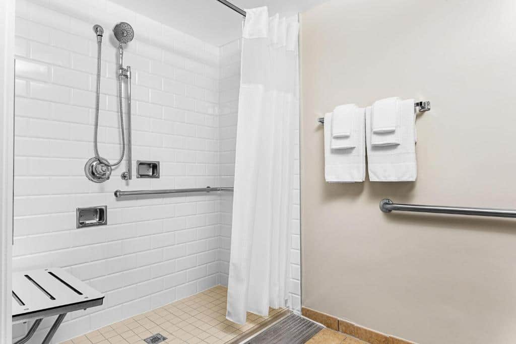 banheiro acessível do Marriott's Grande Vista, com muitas barras de apoio, box de cortinas, chuveirinho e cadeira de banho