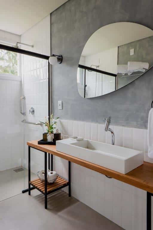 banheiro da vila nambu mostrando a pia no canto direito e o box do chuveiro no canto esquerdo com barras de apoio na parede
