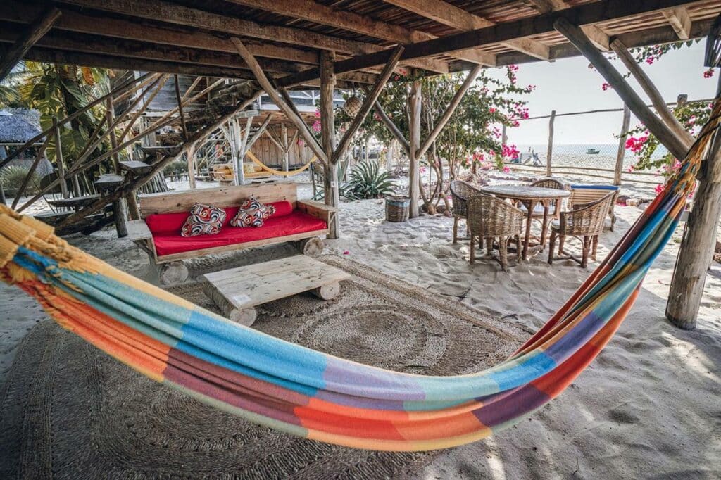 Lounge do bangalo frente ao mar, com sofá e rede de descanso