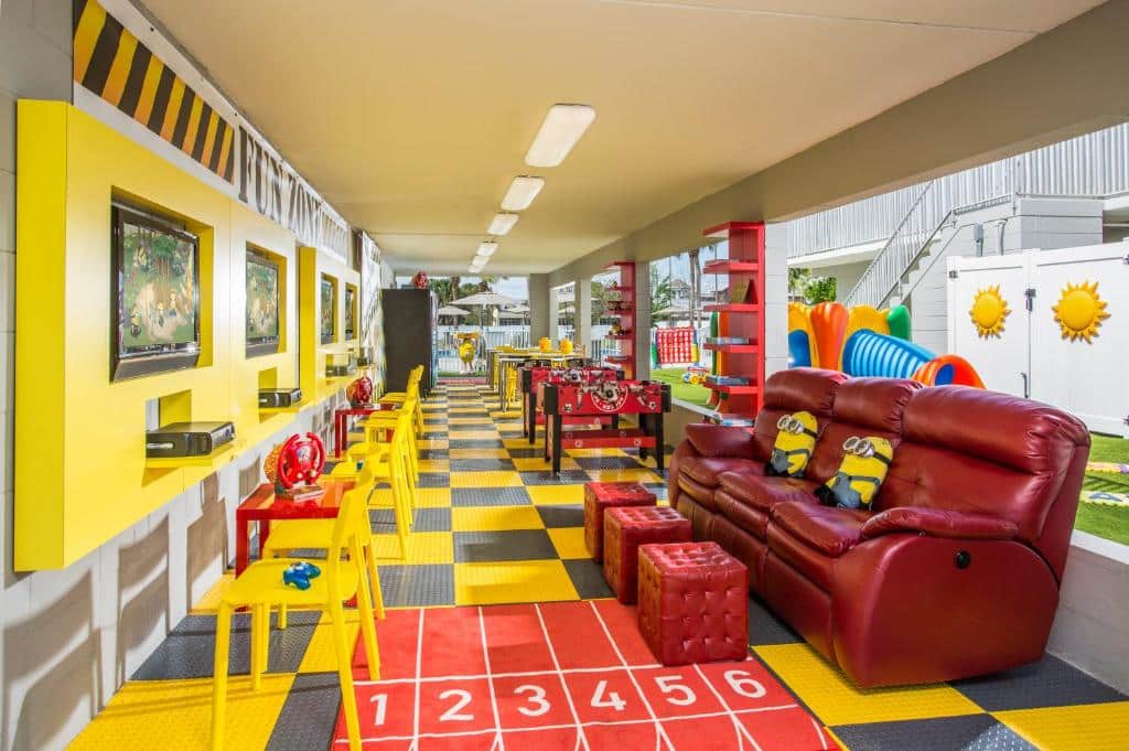 brinquedoteca do Magic Moment Resort and Kids Club um dos hotéis em Kissimmee com desenhos no chão, sofás grandes com puffs e bonecos, além de jogos nas paredes e mais brinquedos