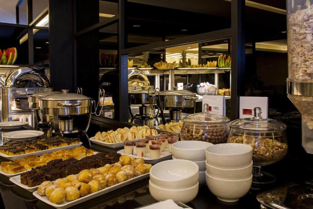 Café da manhã, com pães doces e salgados, pratos para se servir e uma variedade de comida. Foto para ilustrar post sobre hotéis perto do Consulado Americano no Rio de Janeiro.