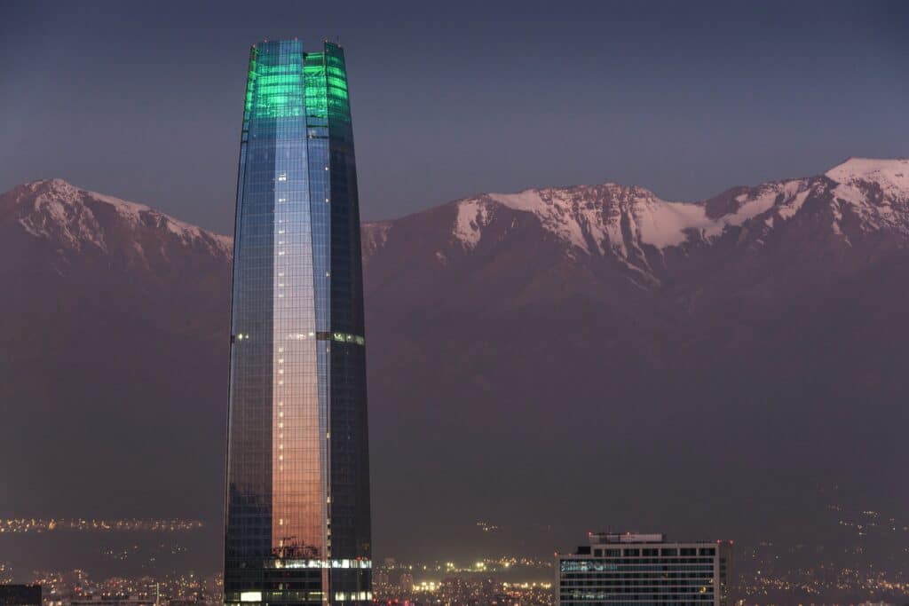 Vista do Sky Costanera, Santiago, Chile  durante o dia com prédios em volta e ao fundo das montanhas.