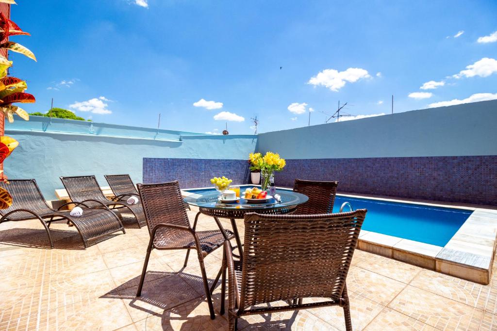 Mesa marrom com comidas em cima em frente a piscina azul durante o dia, ilustrando post Hotéis em Barretos.