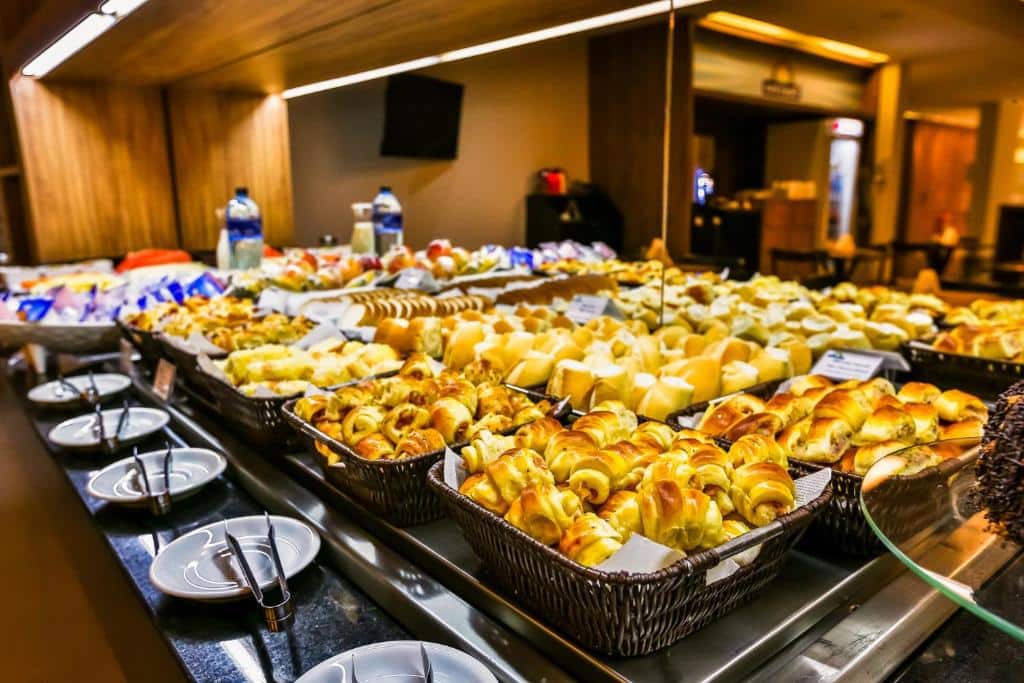 Uma mesa cheia de pães, salgados, e variedade para o café da manhã. Foto para ilustrar post sobre hotéis perto do Consulado Americano no Rio de Janeiro.
