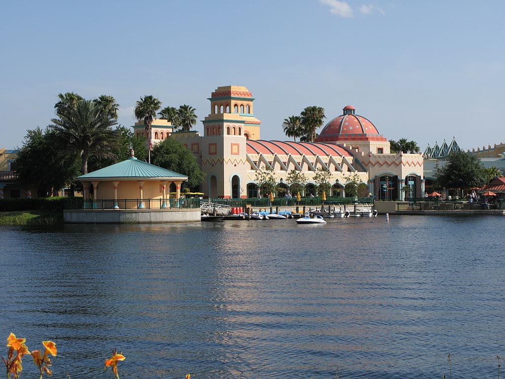fachada vista de um lago com um porto colorido com alguns barquinhos do Disney's Coronado Springs Resort