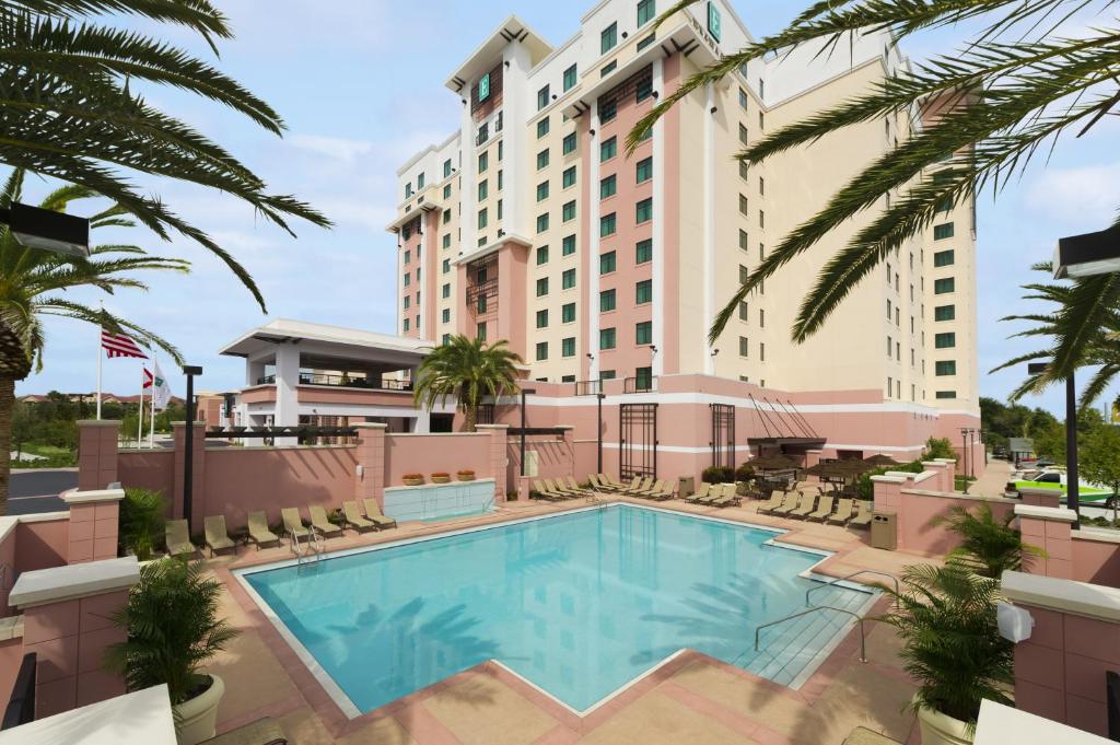 fachada alta com várias janelinhas com a piscina abaixo com bordas quadradas no Embassy Suites by Hilton Orlando Lake Buena Vista South, um dos hotéis em Kissimmee