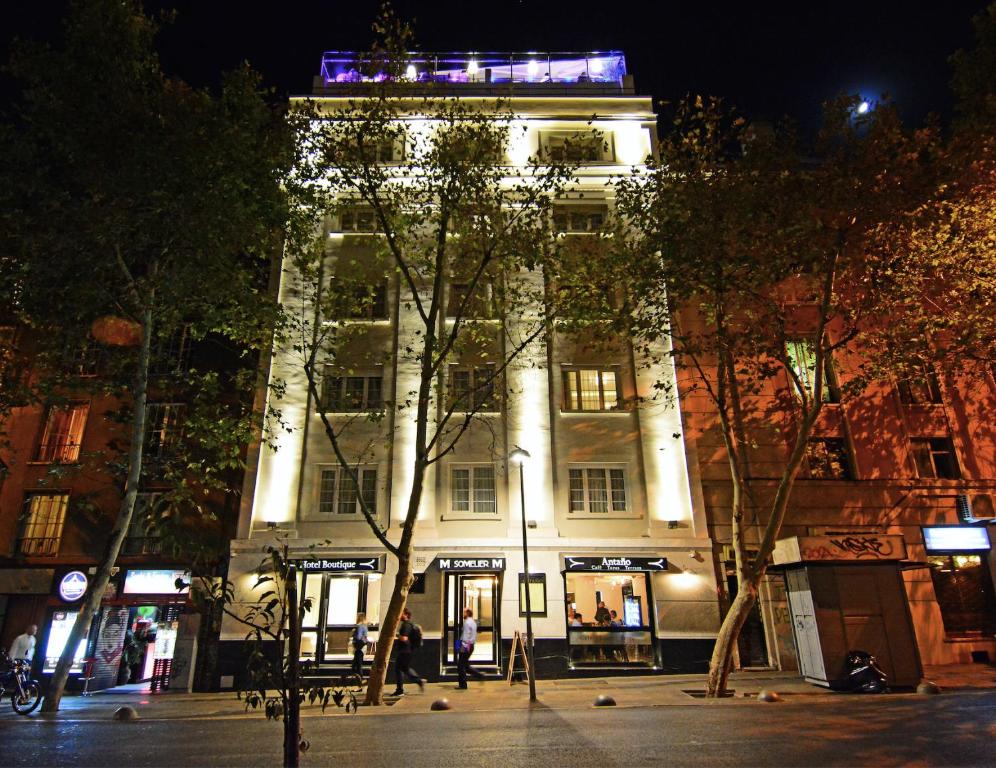 Frente do Hotel Sommelier Boutique durante a noite com árvores a frente. Representa hotéis boutique em Santiago.